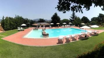 Een seizoensgebonden buitenzwembad, parasols voor strand/zwembad