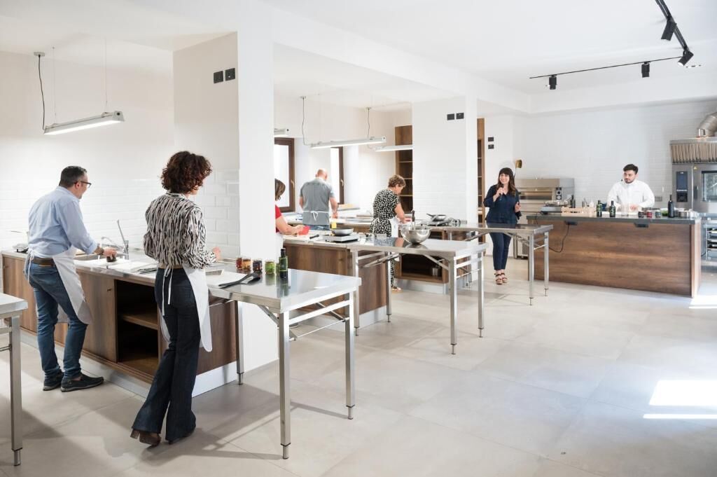 Una cucina moderna con elettrodomestici in acciaio inossidabile, mobili bianchi e un'isola centrale.