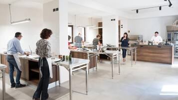 Una cucina moderna con elettrodomestici in acciaio inossidabile, mobili bianchi e un'isola centrale.