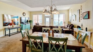 Un comedor con una mesa y sillas de madera, un sofá y una televisión.