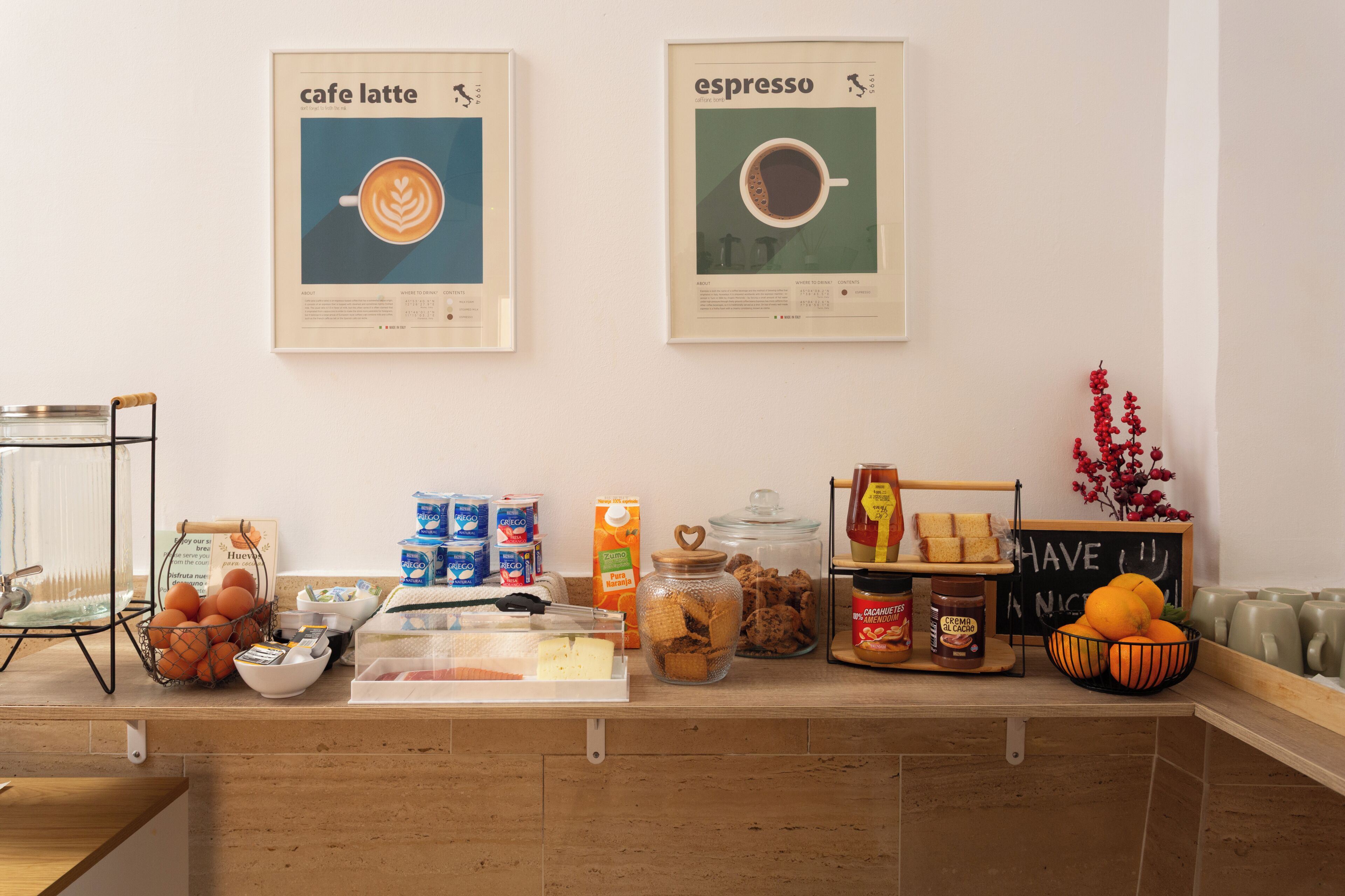 Mostrador de café con carteles de preparación de café, dispensador de agua y diferentes productos alimenticios.