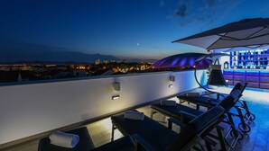 A rooftop terrace with a bar area, seating, and a view of the cityscape at dusk. - La Vie Villa Jelena with rooftop pool, Zadar county (Zadar)