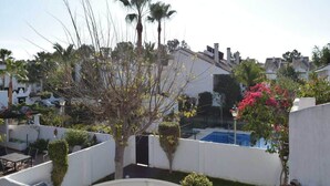 A residential area with a white building, a swimming pool, and palm trees. - Casa Jasmine, Modern Villa for 7 M-3 (Marbella)