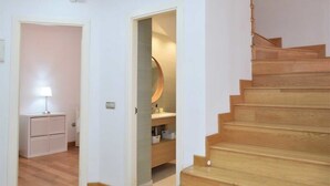 A staircase leading to a second floor, a small desk with a lamp, and a bathroom with a mirror and sink. - Casa Jasmine, Modern Villa for 7 M-3 (Marbella)