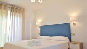 A hotel room with a large bed, two bedside lamps, a nightstand, and a window with curtains. - Casa Jasmine, Modern Villa for 7 M-3 (Marbella)