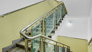 Un escalier doté de rampes en métal et de panneaux en verre ornés de motifs décoratifs.