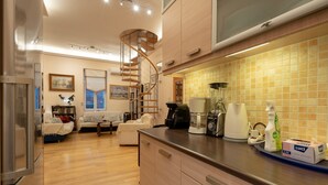 Una cocina moderna con escalera de caracol, armarios de madera y salpicadero de azulejos.