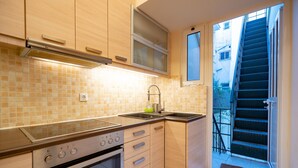 Cocina compacta con horno integrado, fogones y pileta.