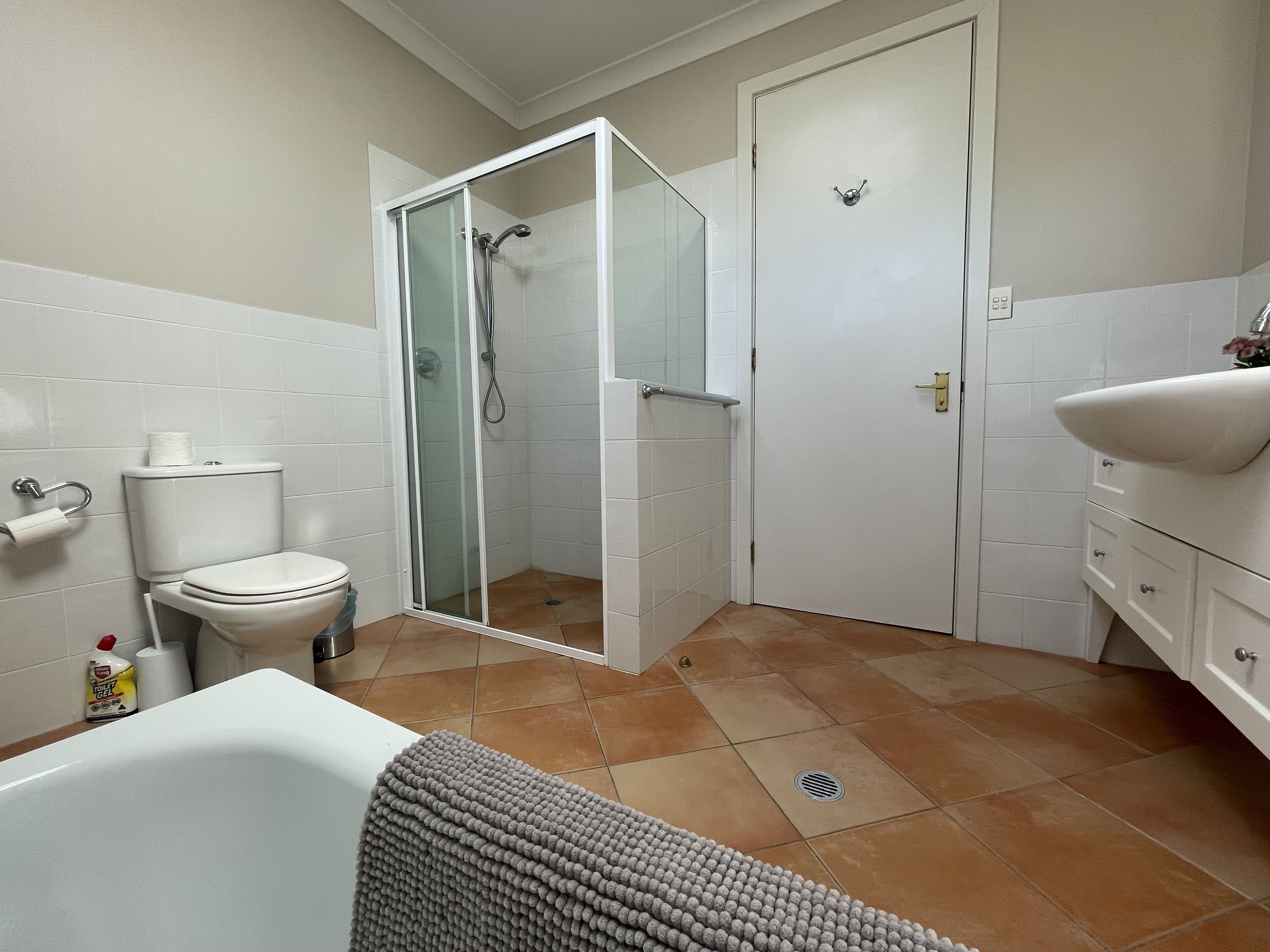 A bathroom with a toilet, shower, sink, and a bathtub.