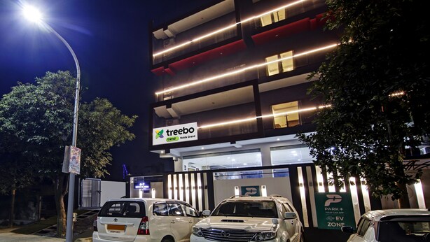 A multi-story parking garage with illuminated signage for 'treebo' and 'Noida Grand'. - Treebo Noida Grand (Noida)
