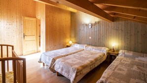 Une pièce en bois avec deux lits, une chaise et une porte.