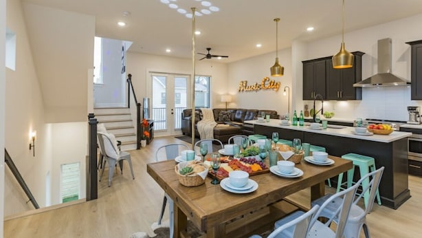 A modern kitchen with dark cabinets, a central island, and pendant lighting. - ​🎉Celebrate in Style! Game Room, 🎱Pool Table,  💃🏼 Dance Pole! (Nashville)