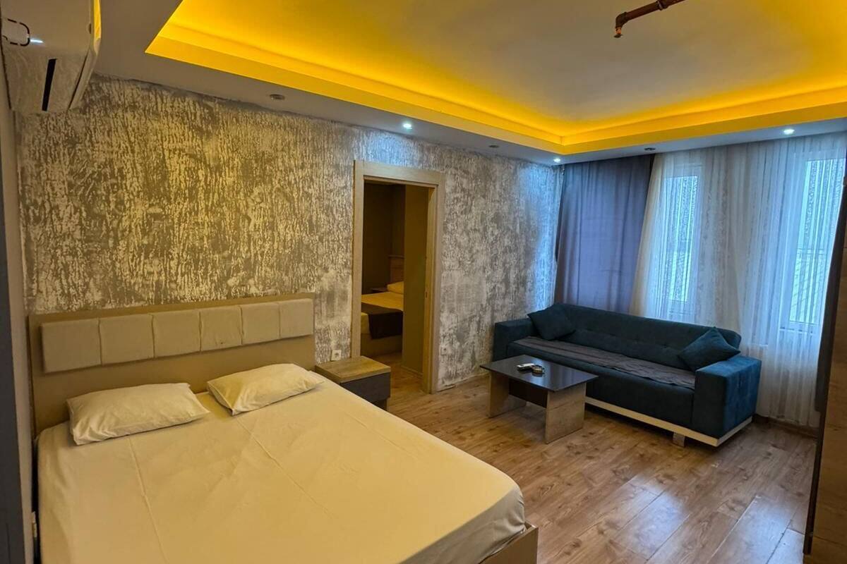 A modern bedroom with a large bed, a sofa, and a small table.