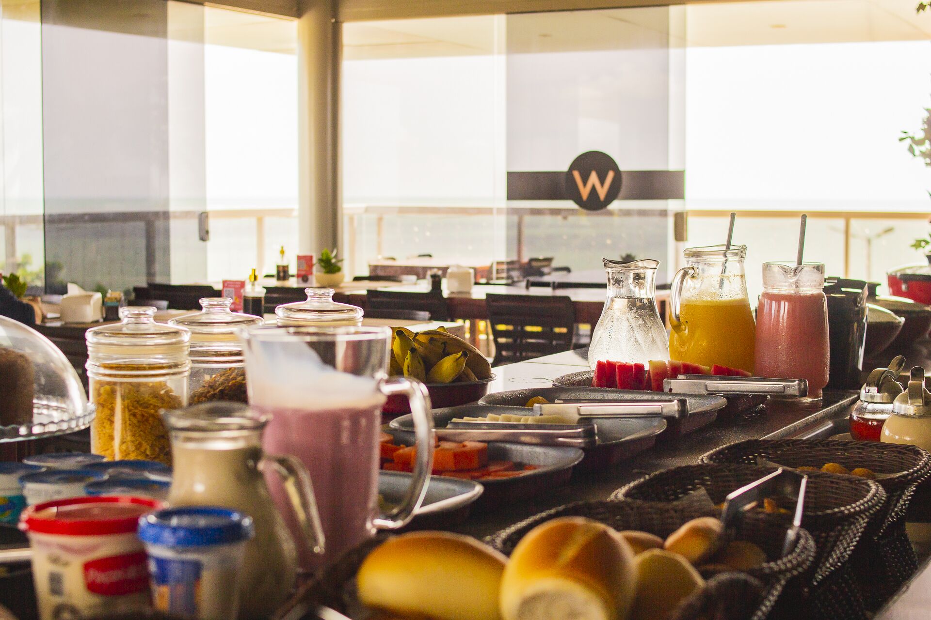 Disposição de buffet com diversos alimentos e bebidas.