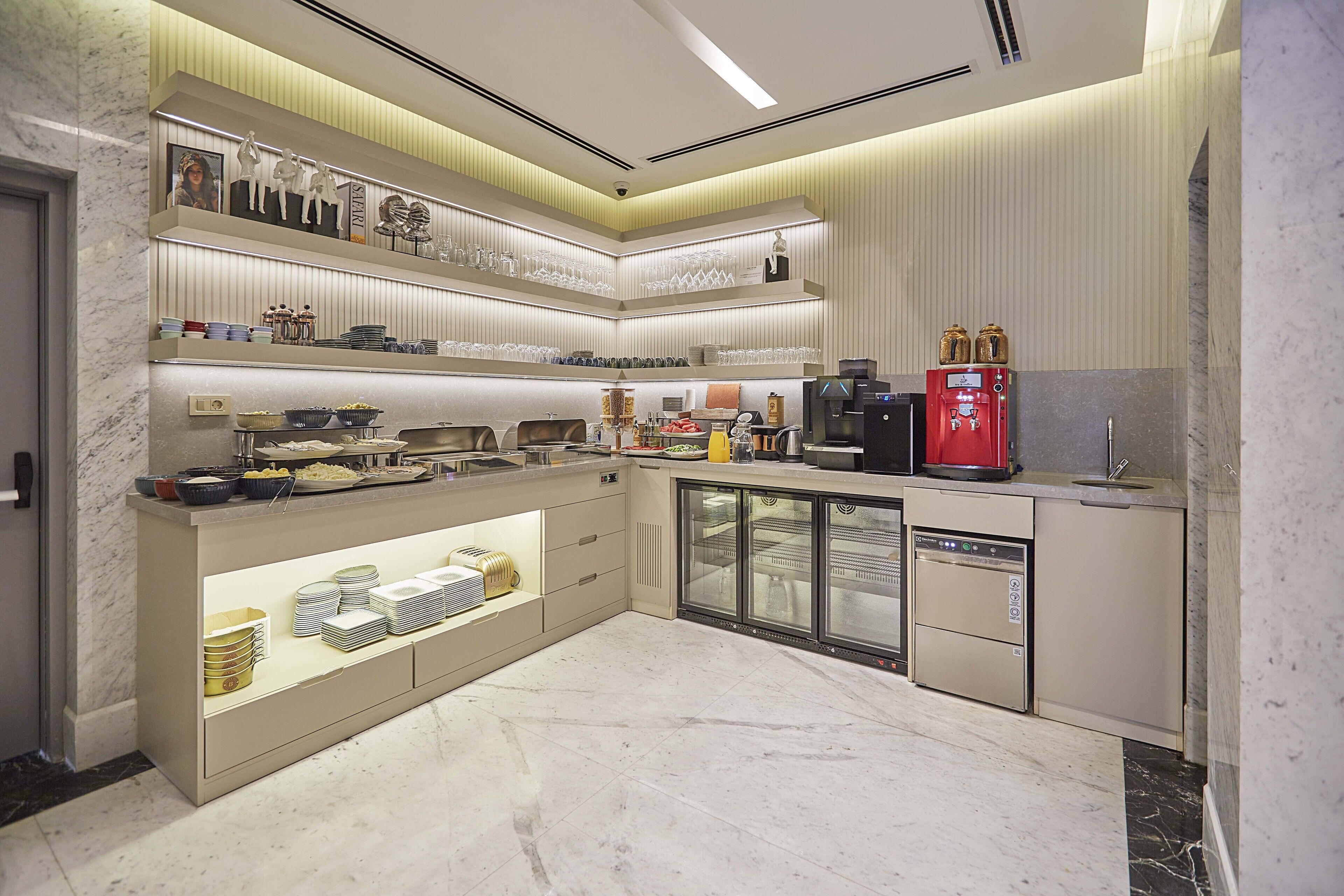 A modern kitchen with marble countertops, built-in appliances, and a coffee machine.