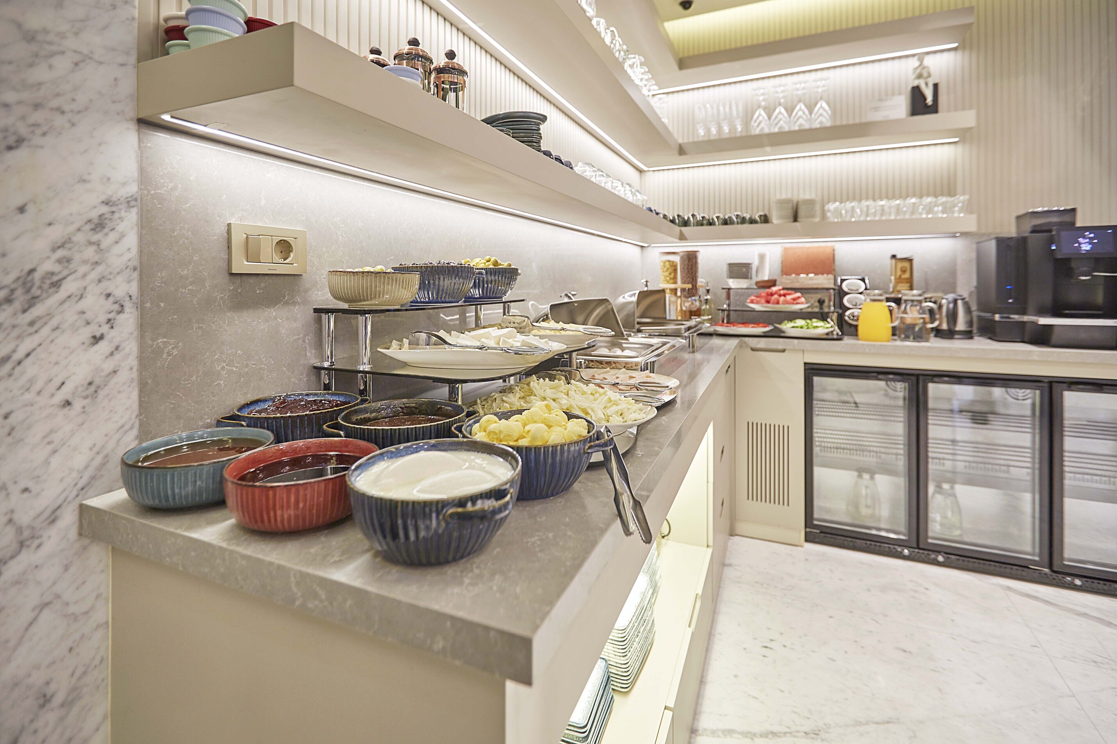 A buffet area with various food items and kitchen appliances.
