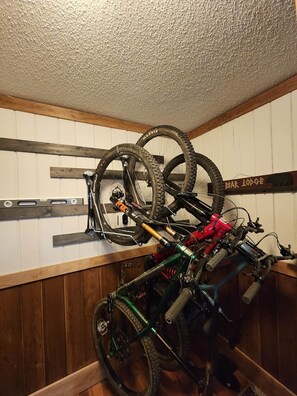 Un perchero de bicicleta instalado en la pared con varias bicicletas y un cartel que dice "BEAR LODGE".