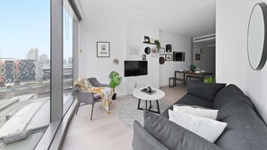 Een moderne woonkamer met een bank, een salontafel en een televisie.