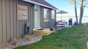 Una casa con un letrero que dice "Houghton Haus" y un patio con una parrilla y una sombrilla.