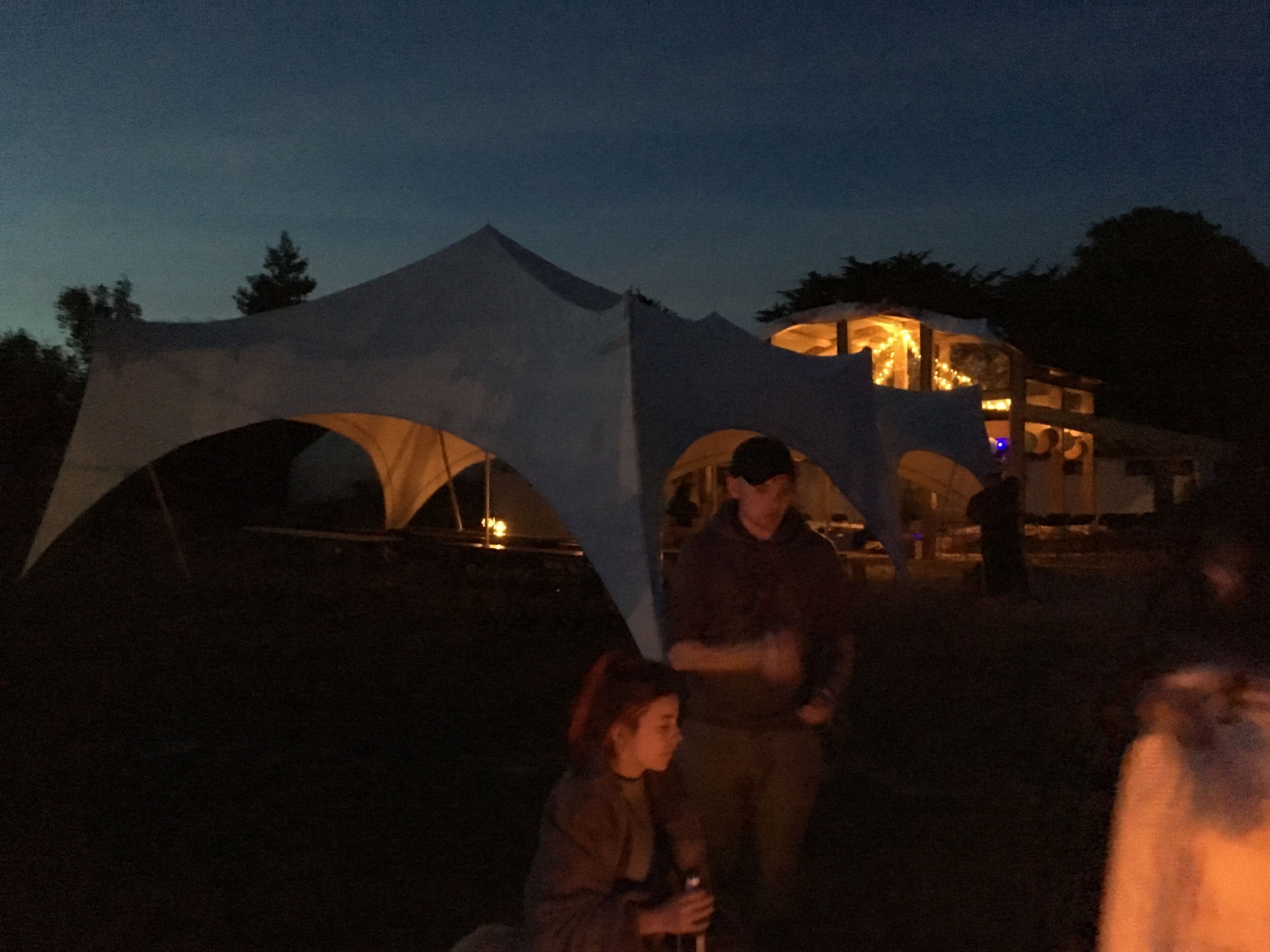 Un espacio al aire libre con carpas y una zona de comedor.