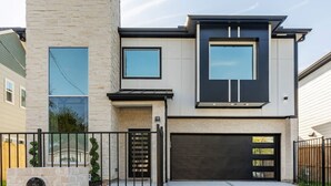 A modern two-story house with a stone facade, large windows, and a garage. - Alim Pad 3: Brand New Modern house near downtown (Houston)