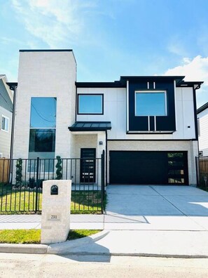 A modern two-story house with a garage, a mailbox, and a well-maintained lawn. - Alim Pad 3: Brand New Modern house near downtown (Houston)
