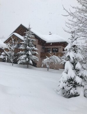 A snow-covered building with a sloped roof, surrounded by snow-laden trees. - Chalet, 250m from ski slopes, balcony, parking, ski locker, 130m², Valloire (Valloire)