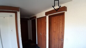 Un passadís amb portes de fusta i una paret blanca.