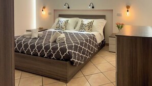 Een moderne slaapkamer met een groot bed, twee nachtkastjes, een nachtkastje en een dressoir.