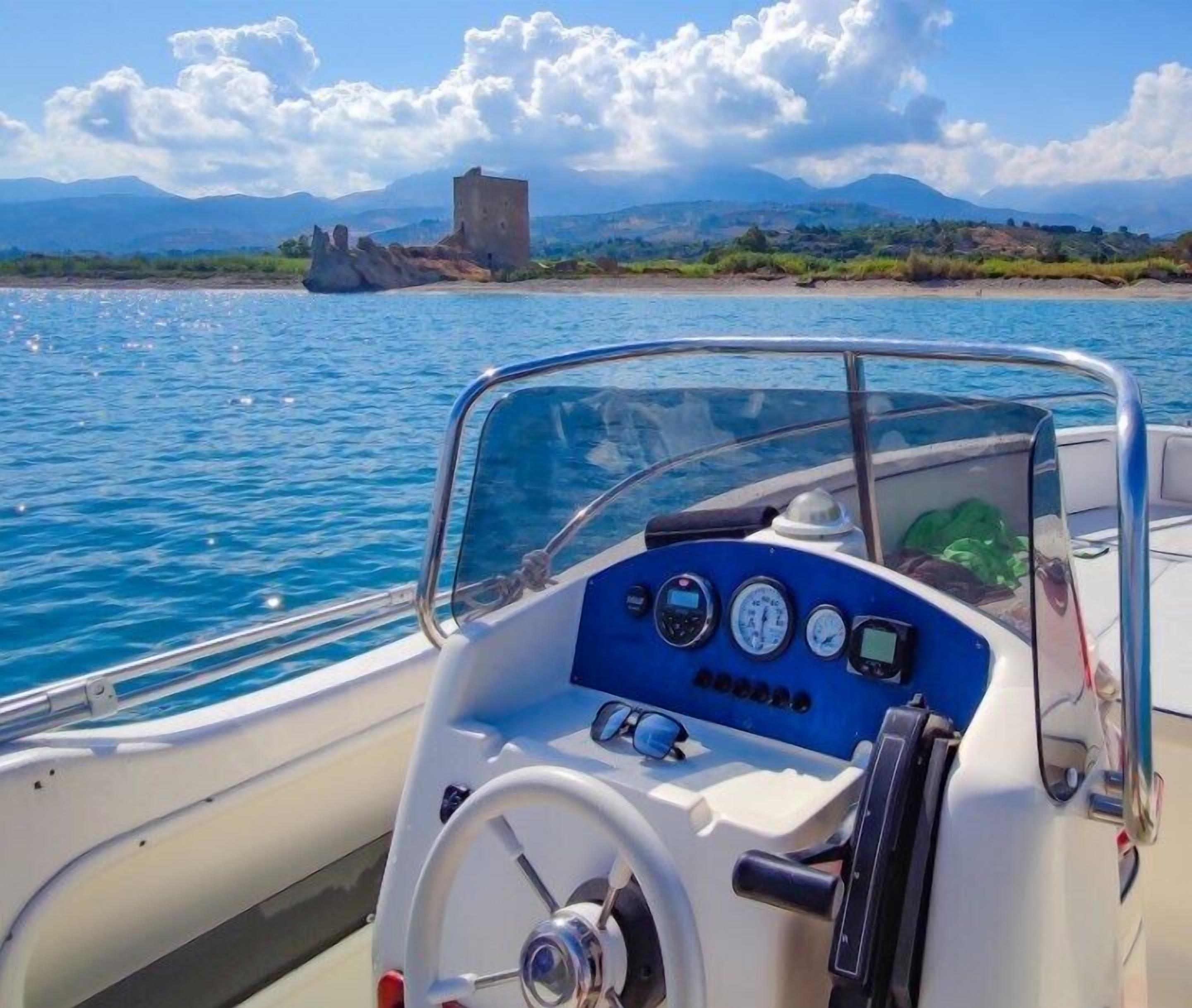 A boat's control panel with a steering wheel, gauges, and a small screen.