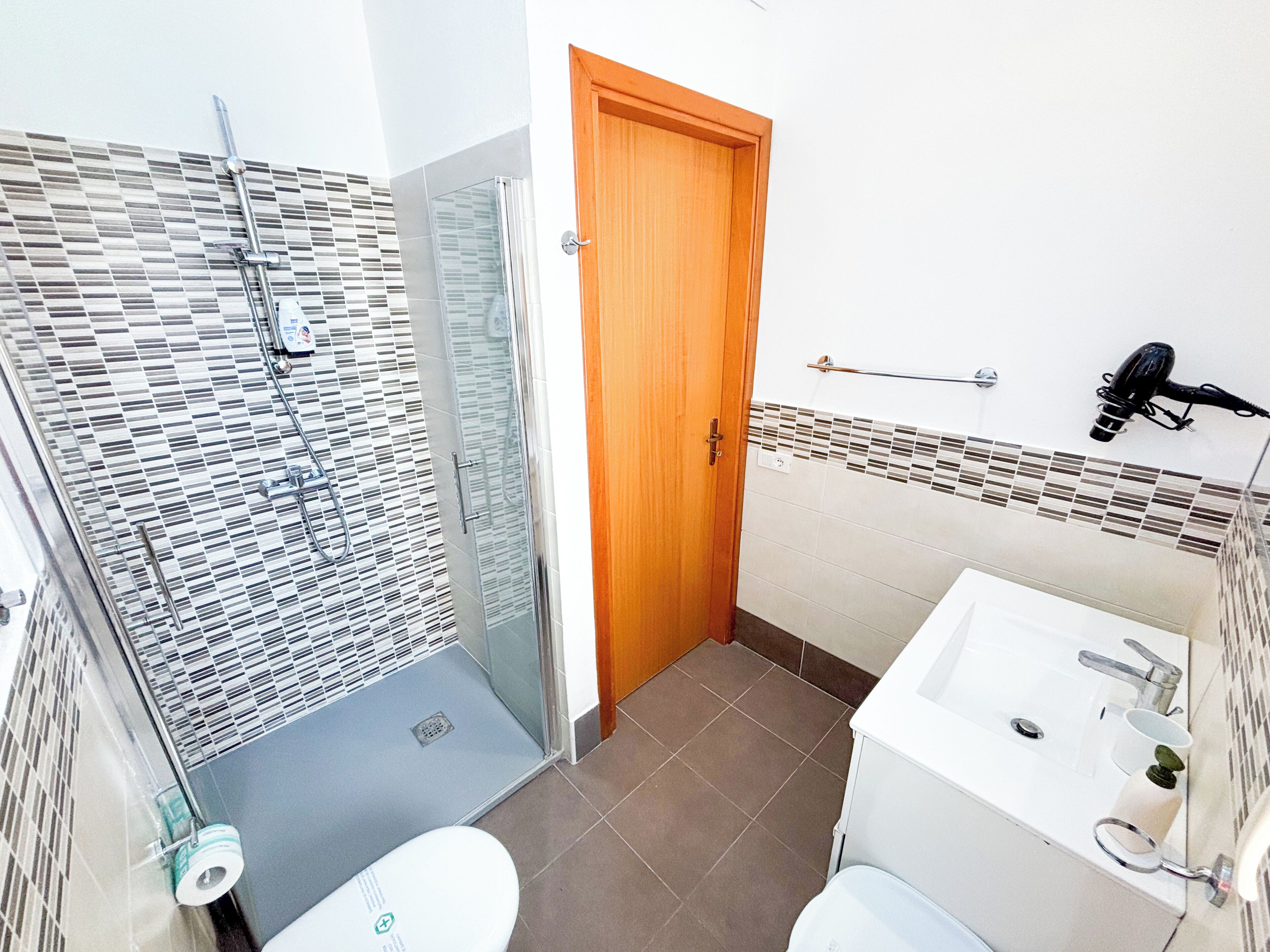 Un baño con ducha, inodoro y lavamanos.