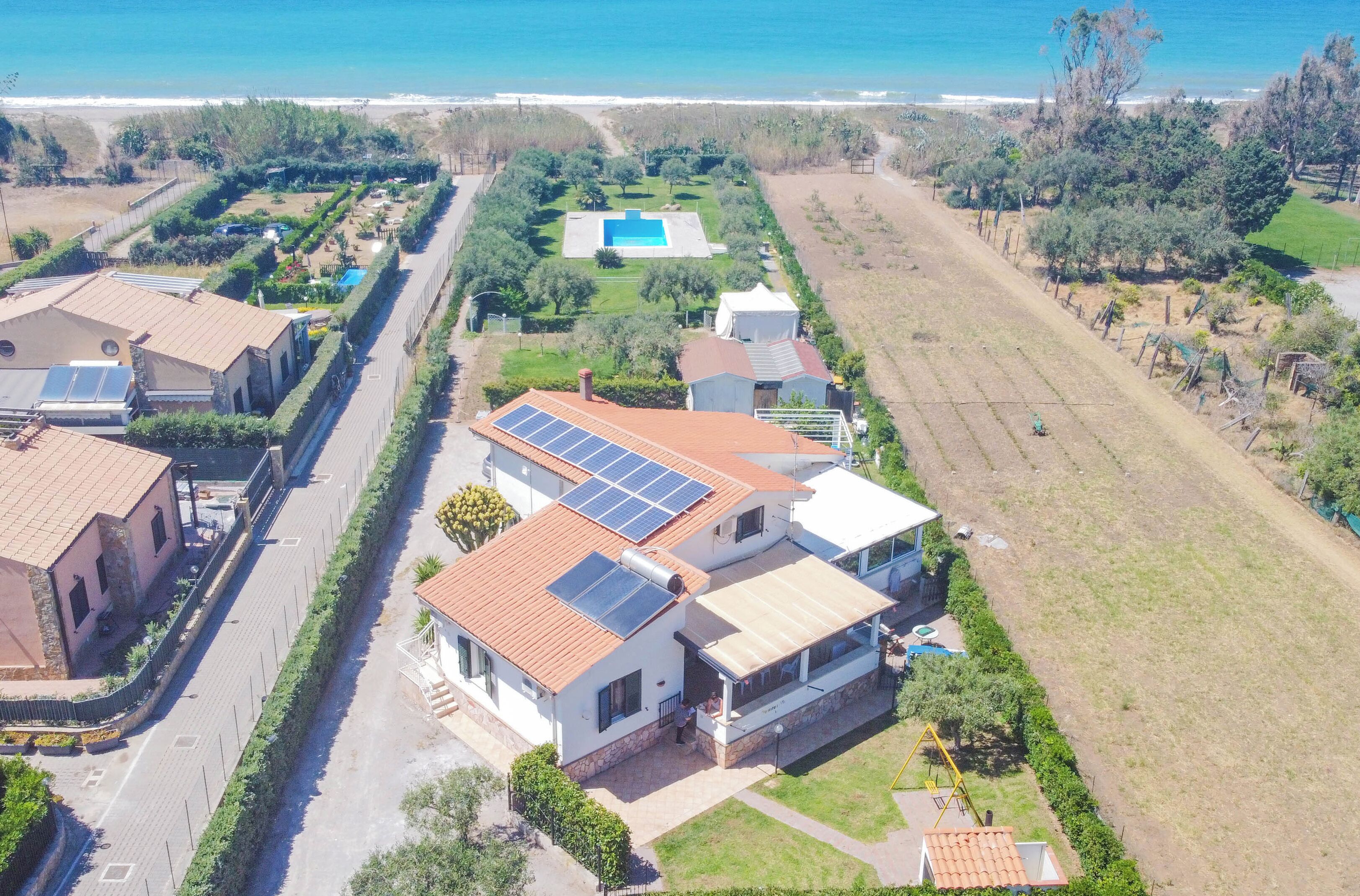 Un barrio residencial con casas, una piscina y vista al océano.