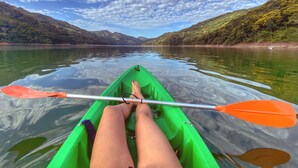 Un kayak en un lago tranquilo con montañas al fondo.