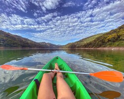 Un kayak en un lago tranquilo con montañas al fondo.