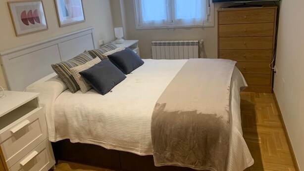 A bedroom with a bed, a dresser, a TV, and a window. - Nice apartment in Candás (Candás)