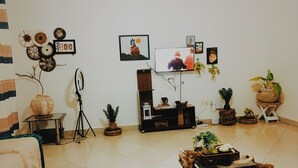 A living room with a TV, various plants, and a rustic coffee table. - 250picnics (Kigali)