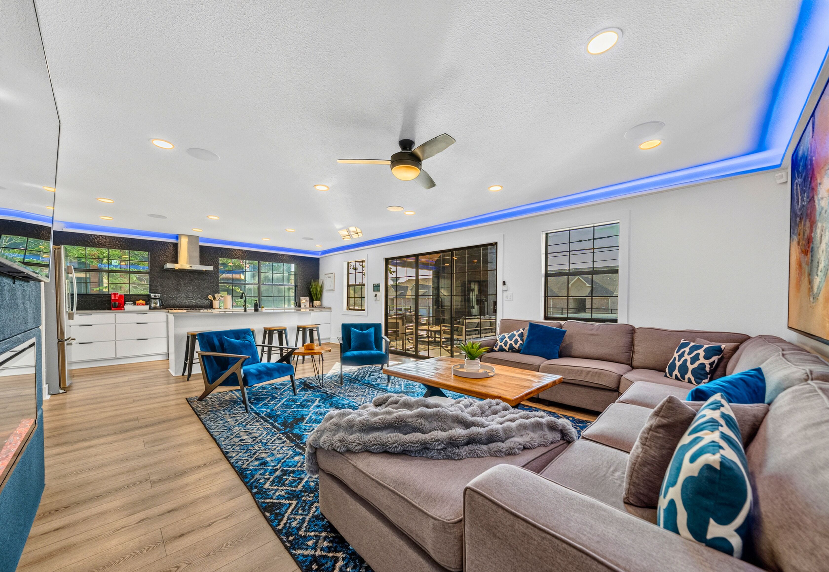 A modern living room with a sofa, coffee table, and blue chairs.