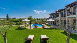 A pool area with lounge chairs, umbrellas, and a clear blue sky. - Holiday apartment with pool near Porec (Poreč)
