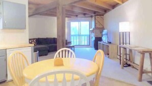 A compact kitchen with a dining area, a sofa, and a view to a balcony. - 2 BR Mountain Condo w/ views, near amazing skiing (Silverthorne)