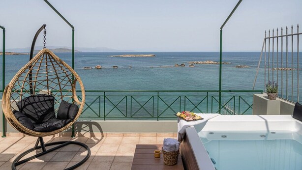 Ein Balkon mit Korbstuhl, Whirlpool und Meerblick.