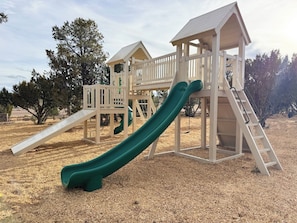 Une aire de jeux avec un toboggan et des structures d’escalade.