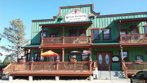 Kaksikerroksinen rakennus, jonka julkisivu on vihreä ja jossa on kyltti, jossa lukee: ”Wild Women Saloon and Grill”.