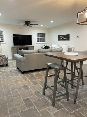 Relax in this stylish living room with a large flat-screen TV, comfortable sofa, and wooden coffee table.