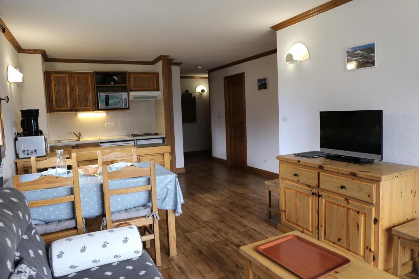A compact living space with a kitchenette, a dining area, and a TV.