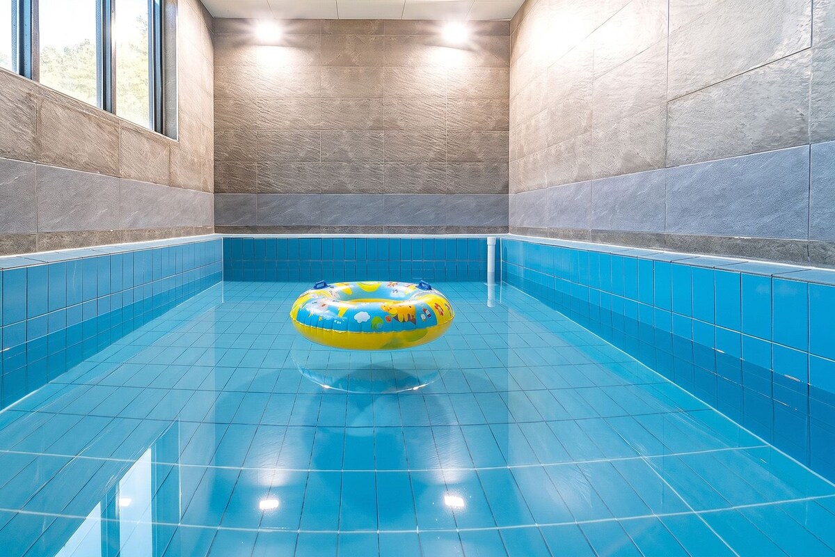 A swimming pool with blue tiles and a yellow inflatable ring.