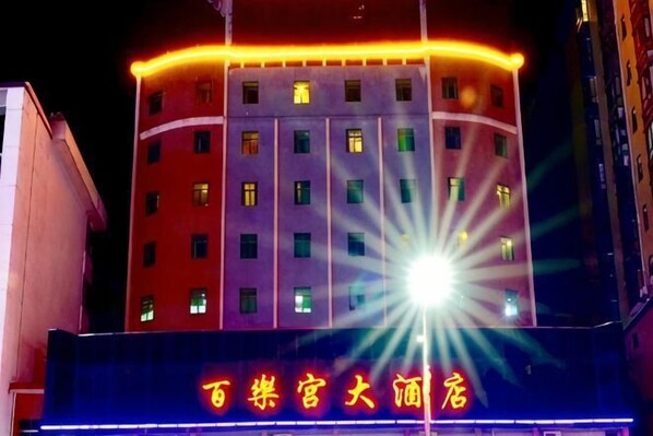 A multi-story building with illuminated signage and windows.
