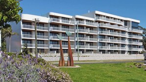 A multi-story hotel with balconies, a landscaped garden, and a sign for a restaurant. - Stunning 1-Bed Bayside Apartment with Superb Views (Batemans Bay)