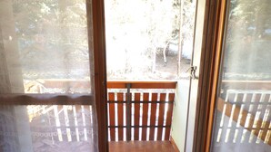 A room with a sliding glass door leading to an outdoor balcony with a wooden railing. - FOUX D'ALLOS MEZZANINE STUDIO 28M2 (foux d'allos)