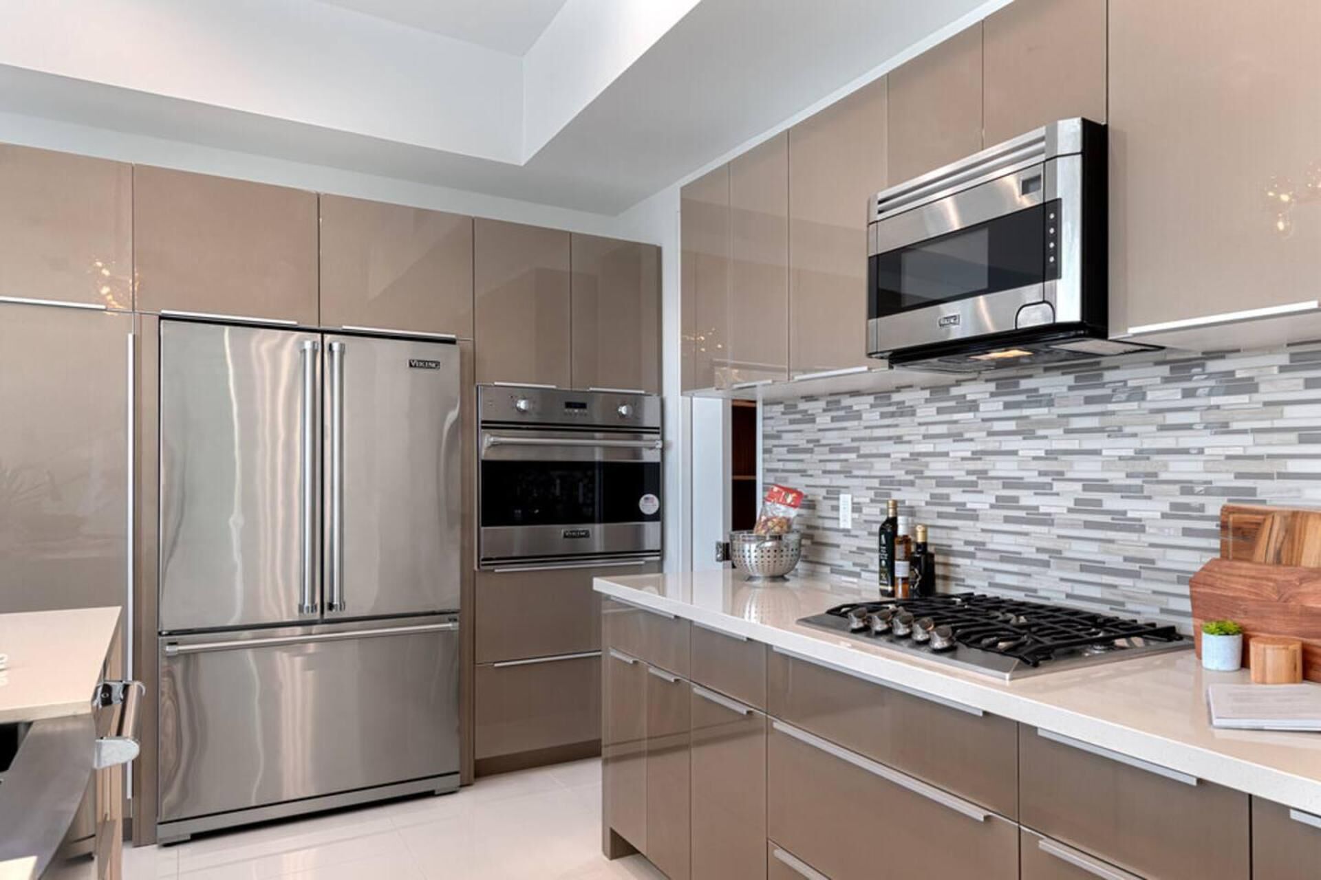 A modern kitchen with stainless steel appliances, a tiled backsplash, and a gas stove.
