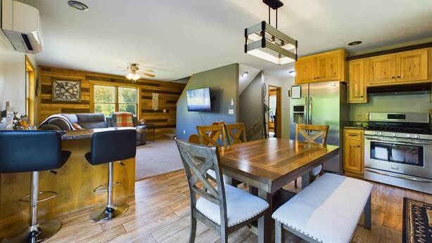A modern kitchen with wooden cabinets, a stainless steel refrigerator, and a built-in oven.